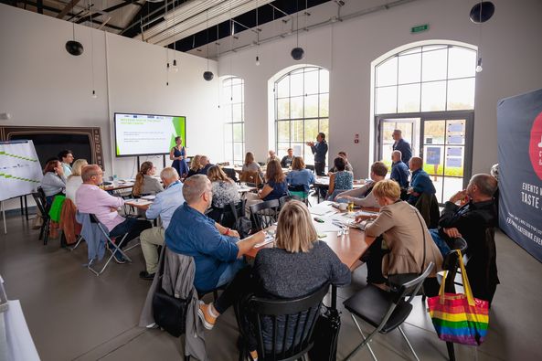 a color photo of people sitting at tables at workshops 