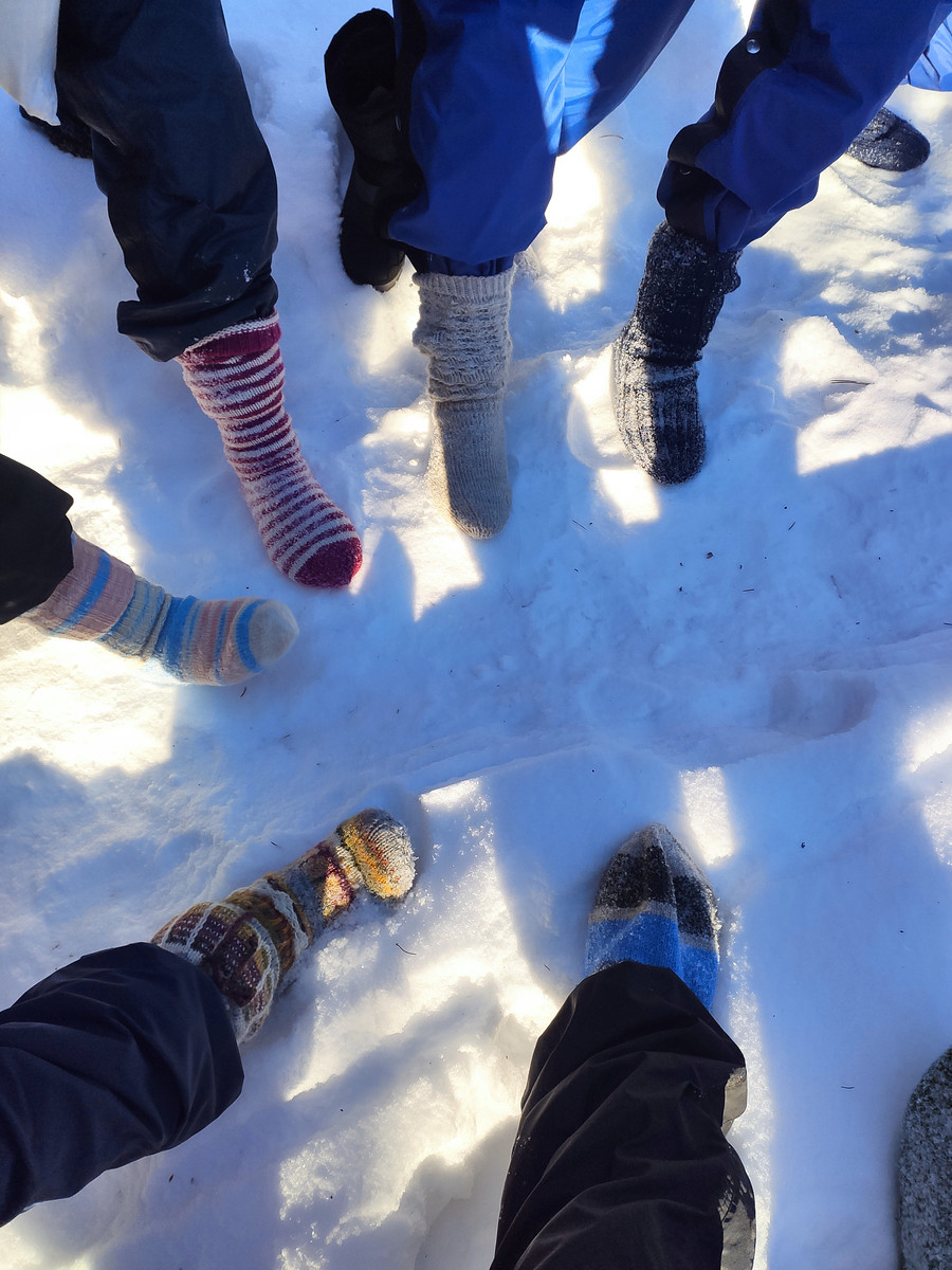 Menschen mit Wollsocken im Schnee.