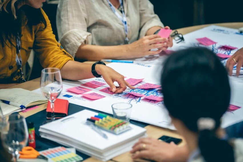 Personen die zusammen an der Methode "problem tree" arbeiten