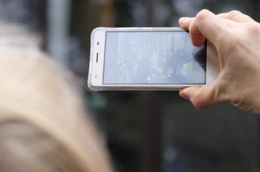 Women using her phone to take a picture at the Tallinn URBACT City Festival