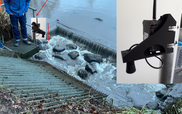 A water monitoring or measurement setup at a small dam or weir on a river. 