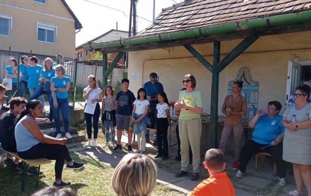 Group of people gathered in a garden to discuss.